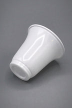 A glossy white polystyrene single serve recyclable cup with a flared rim, shown from a side angle on a neutral grey background.