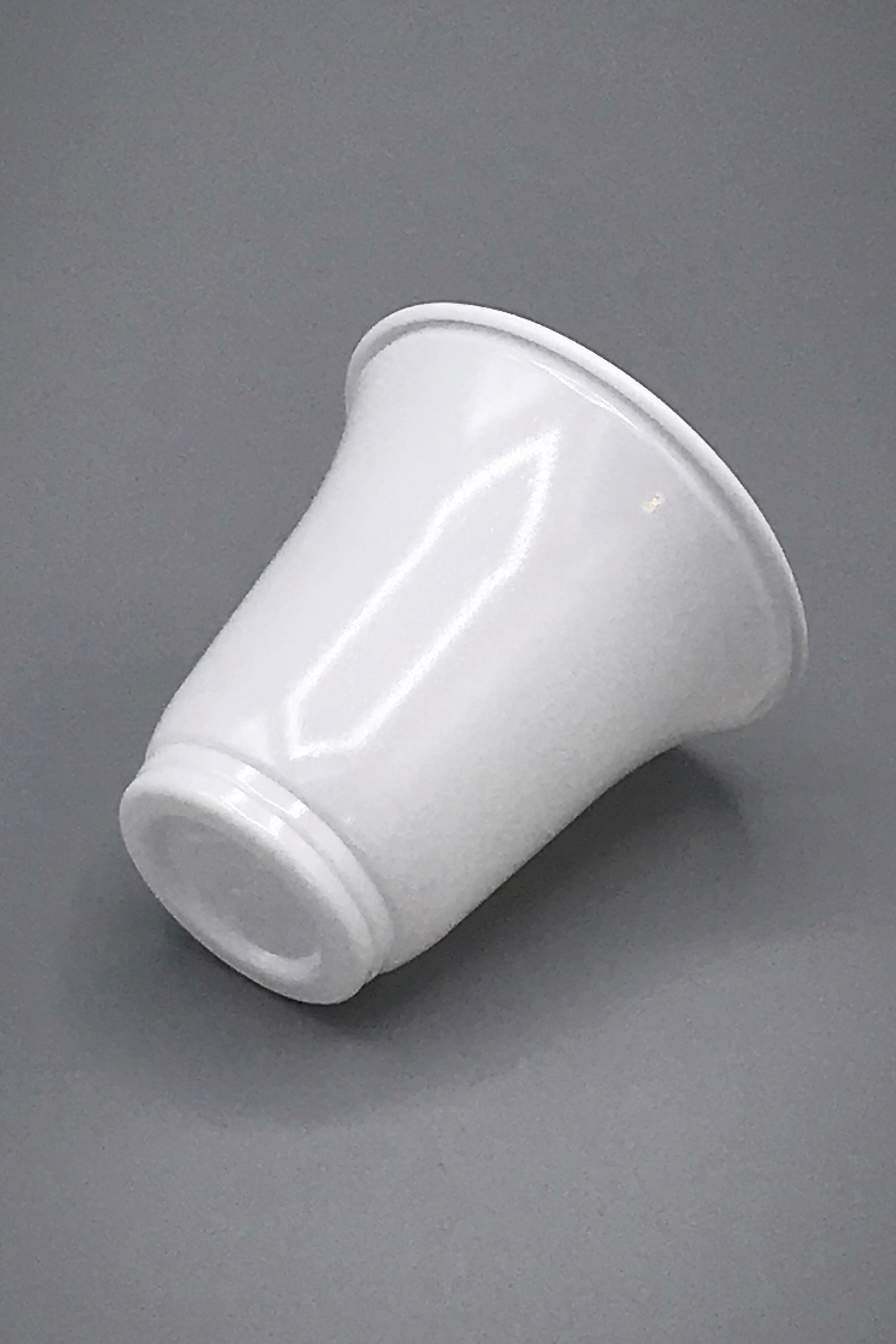 A glossy white polystyrene single serve recyclable cup with a flared rim, shown from a side angle on a neutral grey background.