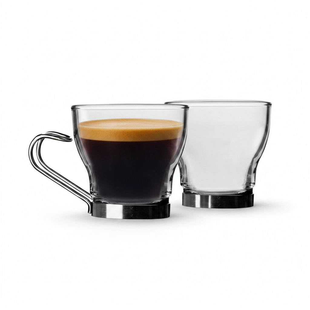 Two clear glass coffee mugs with metal bases and handles, one filled with espresso and one empty, on a white background.